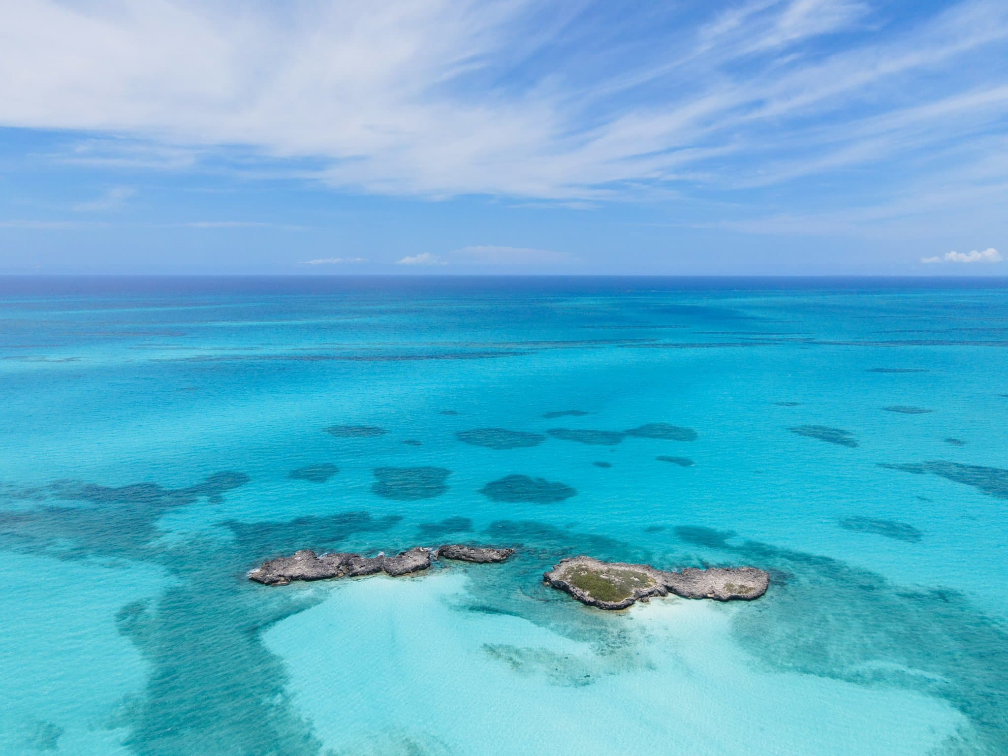A boat tracing the reef line in the turquoise waters of Exuma